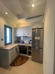 a kitchen with a stainless steel refrigerator and white cabinets at Iconic Project Lagada in Amorgos