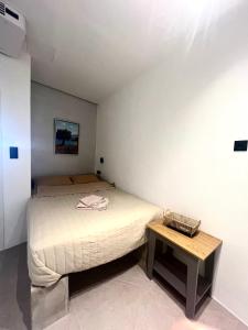 a small bedroom with a bed and a table at Iconic Project Lagada in Amorgos