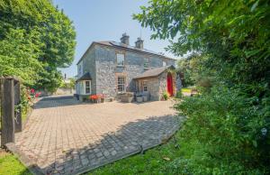 an old stone house with a brick driveway at Knockaderry House in Ennis