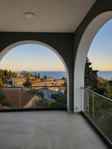 an empty room with two large windows with a view of the ocean at White Arches in Ulcinj