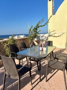 a table and chairs on a patio with the ocean in the background at Roxys sea view Santorini Monolithos in Santorini