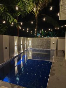 a swimming pool with a blue tiled floor and lights at K&M Studio Suites Casa KM in Bingag +6 photos