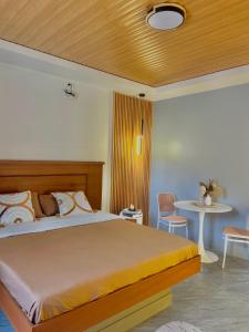 a bedroom with a large bed and a table at K&M Studio Suites Casa KM in Bingag