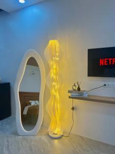a room with a mirror and a yellow lamp at K&M Studio Suites Casa KM in Bingag
