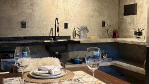 a kitchen with a table with two wine glasses at Exclusive Huts in Gravatá