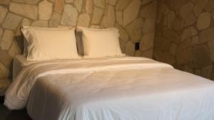 a bed with white sheets and pillows in a room at Exclusive Huts in Gravatá +36 photos