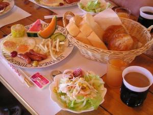 una mesa cubierta con platos de comida y bebida en Strawberry Farm Shirasaki en Yura