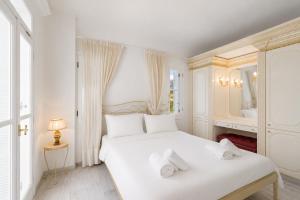 a white bedroom with a bed with towels on it at Villa Cypress with Private Pool and Mountain Views in Andros
