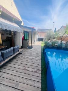 a deck with a swimming pool next to a house at Chalet cosy atypique avec petite piscine in Vichy