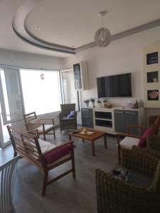 a living room with chairs and a couch and a tv at Huge oceanfront apartment in Tétouan