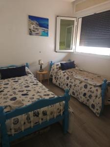 a bedroom with two beds and a window at Huge oceanfront apartment in Tétouan