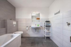 a bathroom with a sink and a toilet and a tub at Fuchskreuzhof Simmersfeld in Simmersfeld +18 photos
