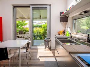 a kitchen with a sink and a table with chairs at Villa Mulberry Garden by Interhome in San Marcello