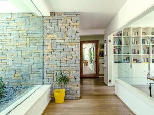 a living room with a stone wall and a hallway at Villa Mulberry Garden by Interhome in San Marcello