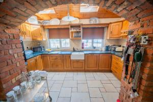 a kitchen with wooden cabinets and a brick wall at Knockaderry House in Ennis