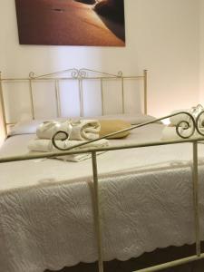 a bed with a metal frame and white sheets at A casa di Nonna Maria in Marsala