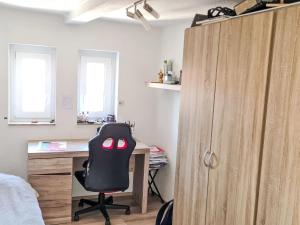 a bedroom with a desk and a black chair at Apartment Workbase Nidderau by Interhome in Nidderau