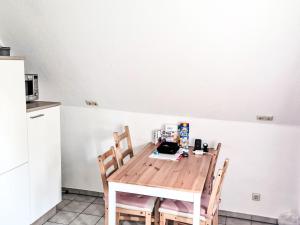 a kitchen with a wooden table with chairs and a counter at Apartment Workbase Nidderau by Interhome in Nidderau