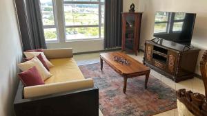 ein Wohnzimmer mit Sofa, Tisch und Fernseher in der Unterkunft Diamond View in Quatre Bornes