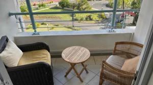 ein Balkon mit zwei Stühlen, einem Tisch und einem Fenster in der Unterkunft Diamond View in Quatre Bornes