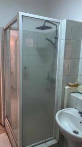 Eine Dusche mit Glastür neben einem Waschbecken in der Unterkunft Diamond View in Quatre Bornes + 2 Fotos