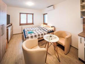 a small room with a bed and two chairs and a table at Studio V Šachu-3 by Interhome in Dačice