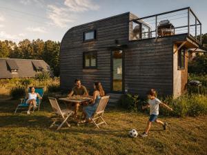 a family playing with a soccer ball in front of a house at Graine d'insolite in Imbleville
