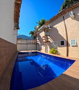 a swimming pool next to a house at Chale Maresias 1 in São Sebastião