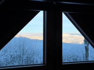 a window with a view of a snowy mountain at Shawnee Ridge Lodge in Banner Elk