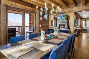 a dining room with a wooden table and blue chairs at Shawnee Ridge Lodge in Banner Elk
