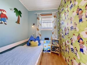 a bedroom with a bed and a wall with cartoon characters at Apartment Gabi-2 by Interhome in Wiek auf Rügen