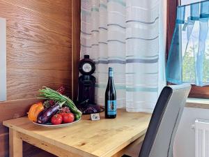 a table with a bottle of wine and a plate of vegetables at Studio Sirch-1 by Interhome in Diedorf