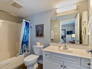 a bathroom with a toilet and a sink and a mirror at Oceanfront Get Away in Myrtle Beach +12 photos