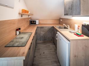 a small kitchen with wooden counters and a sink at Studio V Šachu-4 by Interhome in Dačice
