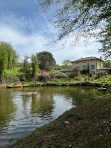 a house next to a river with a house at Les CHAMBRES des EAUX in Sarcey
