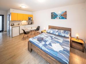a bedroom with a large bed and a kitchen at Studio V Šachu-2 by Interhome in Dačice