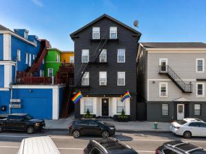 a large black house with flags in a parking lot at Pride House in Providence