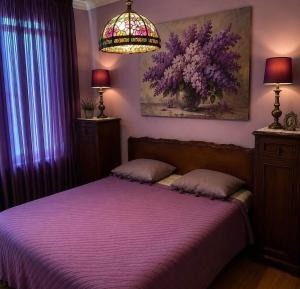 a bedroom with a bed with purple sheets and a lamp at Sea & Sun Grigoleti in Grigoleti