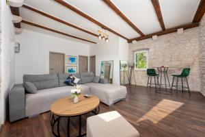 a living room with a couch and a table at Authentic Dalmatian Stone House-Kameni dvori in Selca kod Bogomolja