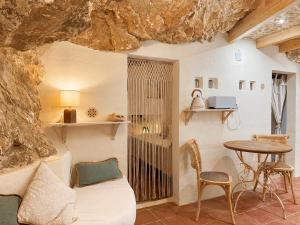 a room with a bed and a table in a cave at La Cueva De Orel in Molinicos