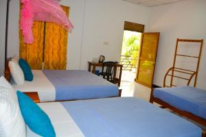 a hotel room with two beds and a window at Trinco Eddi Resort in Trincomalee