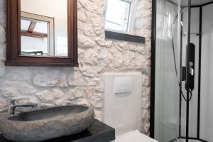 a bathroom with a large stone sink and a mirror at Authentic Dalmatian Stone House-Kameni dvori in Selca kod Bogomolja +43 photos