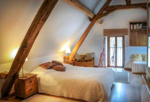 a bedroom with a bed in a room with wooden beams at Gites Arches de Muschamp in Cussay
