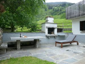 a bench and a table and a chair on a patio at Apartment Rina by Interhome in Olivone