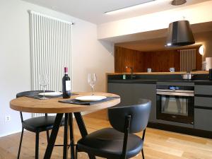 a kitchen with a table with chairs and a bottle of wine at Apartment Rina by Interhome in Olivone +28 photos