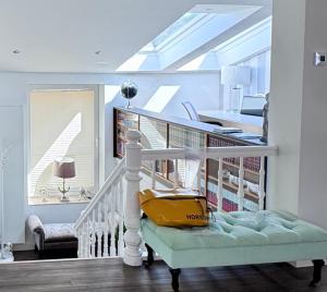 a room with a staircase with a couch and a skylight at Villa Iduna mit modern desingten Apartments in Graal-Müritz