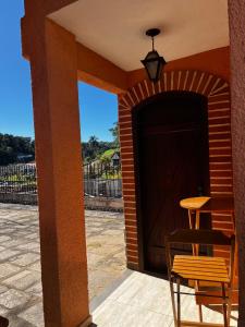 a wooden garage door with a table and a chair at Encanto da Serra 2 in Miguel Pereira