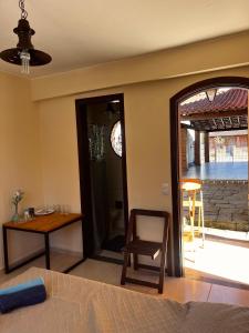a bedroom with a table and a chair and a desk at Encanto da Serra 2 in Miguel Pereira