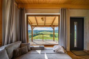 a living room with a couch and a large window at Kamienny Horyzont in Bereżnica Wyżna