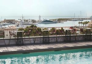 a pool with chairs and a cruise ship in the water at Catalonia Molina Lario in Málaga